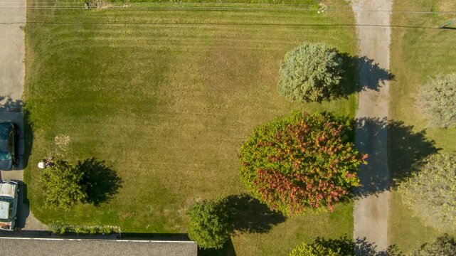 Aerial top down view of mowing a large green lawn