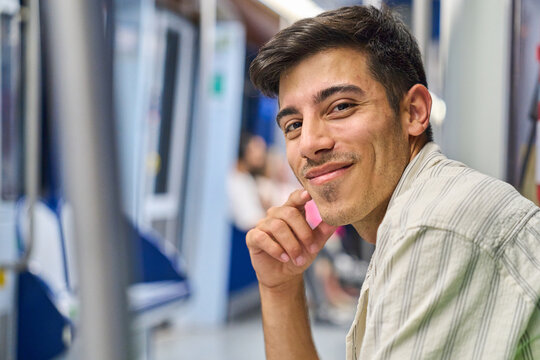 Young man smiling during daily subway commute