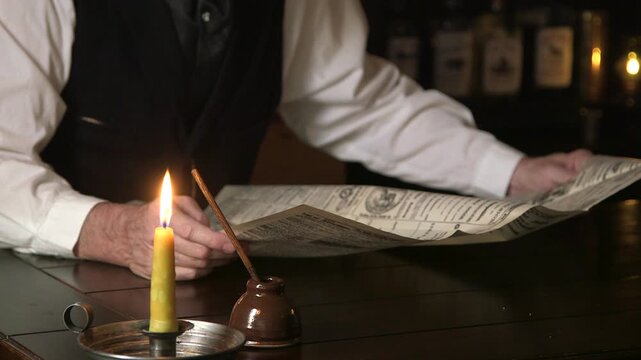 1880 man reading newspaper focus on inkwell