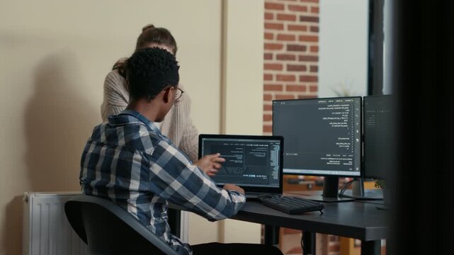 Two software developers reacts to successful algorithm results beside running code screens, marking a collaborative development milestone with a high five, while comparing programming results.