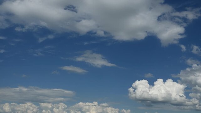 Summer blue sky in this timelapse of moving white clouds. The clouds are moving in two different directions
