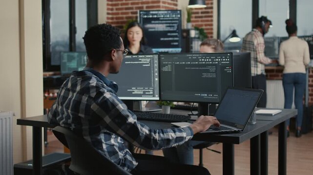System engineer develops interface concepts around programming data, using office collaboration to refine cloud software workflow and UI logic, inside a data processing room.