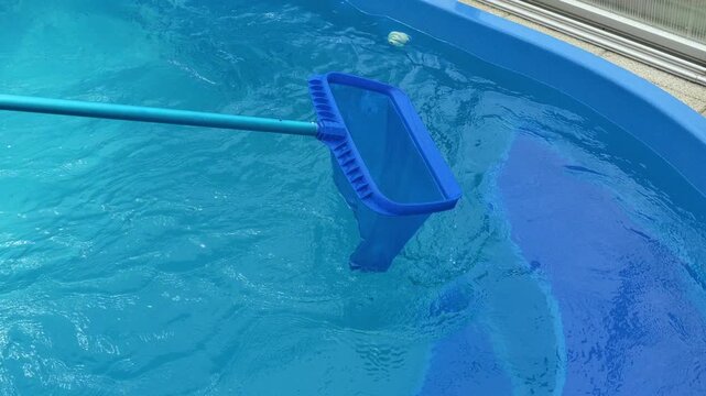 swimming pool equipment. Pool skimmer net cleaning clear blue swimming pool water. 4k footage