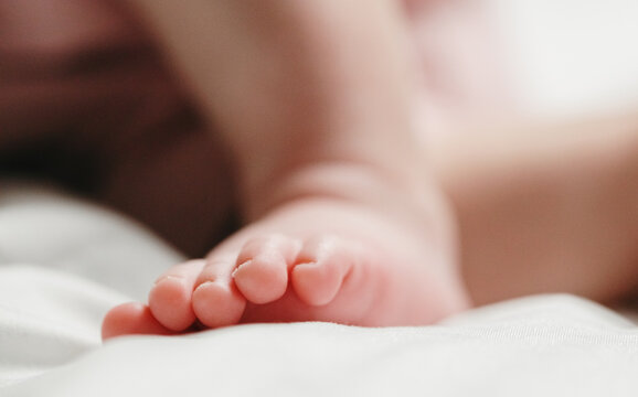 A close-up portrait of the cute toes on the foot of a sleeping Caucasian newborn baby.