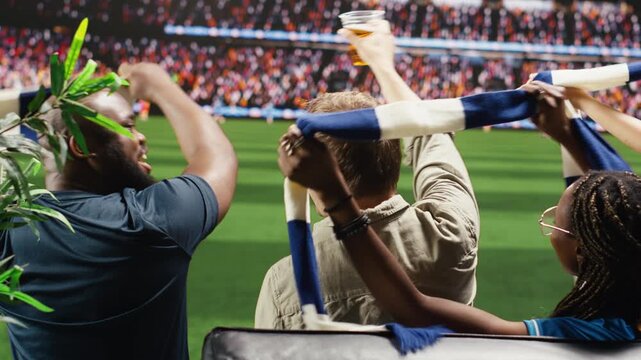 Tight framing shows soccer fans following soccer match from couch while using scarves for team support, high fidelity sports broadcast delivering lifelike stadium realism, panning shot.