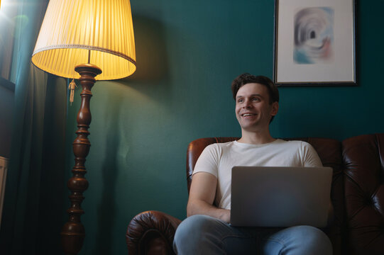 Smiling Man Relaxing With Laptop at Home With Copy Space