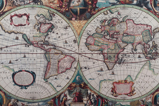 A modern printed reproduction of a 17th century world map by H. Hondius showing the continents, allegorical illustrations and antique commercial maritime routes