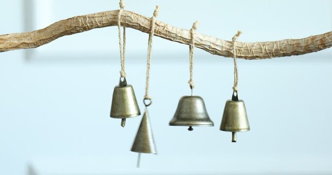 Woman ringing beautiful metal bells indoors, closeup