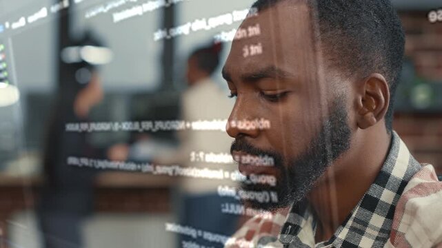 African American software developer studies a hologram style programming display at a desk, connecting artificial intelligence, coding workflow and futuristic technology