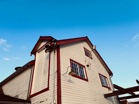 Red and white wooden wall of a historic building under a blue sky