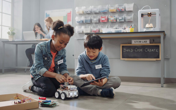 Diverse Kids Programming Robot in STEM Classroom | Elementary School Children Learning Robotics, Coding, and Technology Education in Modern Science Lab