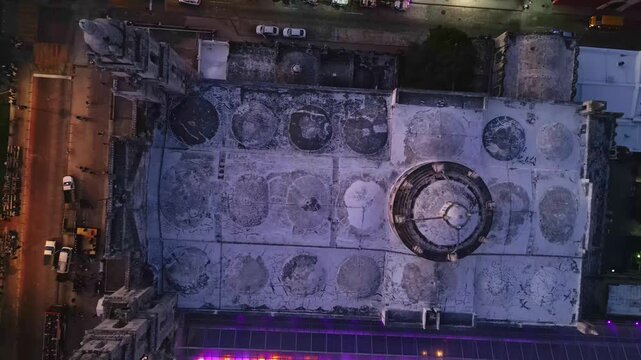 Aerial top view of Merida Cathedral illuminated at night in Mexico, with city traffic creating light trails