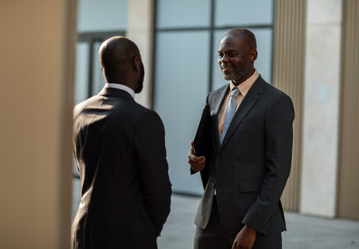 Two businessmen talking outside modern office building