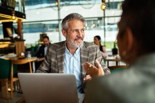 Mature businessman meeting client in modern cafe