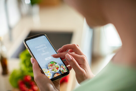 Person using healthy recipe app on smartphone in kitchen
