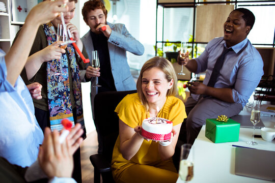 Coworkers celebrating colleague's birthday at office party