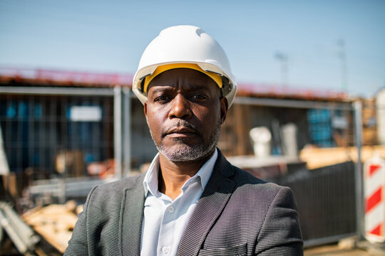 Confident construction manager wearing hard hat at building site