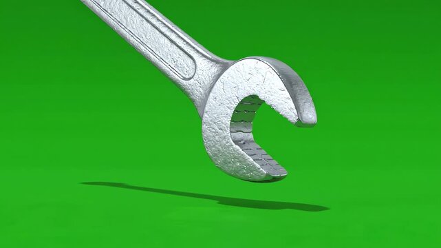 Industrial metal wrench falling in slow motion against a bright green screen background with realistic rotation and shadow
