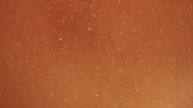Blur sparkling swirl. Paint water. Orange yellow liquid flowing in round glowing lens. Shiny powder particles color abstract background.