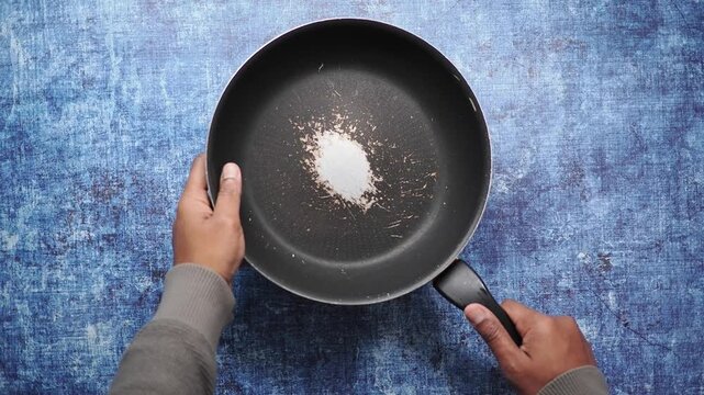top view of hand holding a old cooking pan 
