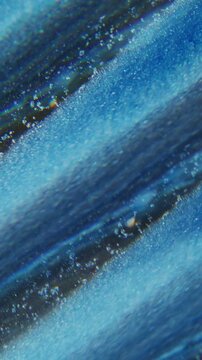 Vertical video. Paint leak blur. Shiny fluid. Glitter stripe trickles stream mix color abstract background. Blue black particles kaleidoscopic spill.