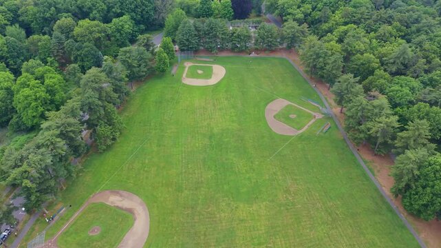 Baseball Field Surrounded By Dense Trees And Parking Lot At Public Park In Springfield, Massachusetts, United States. aerial shot