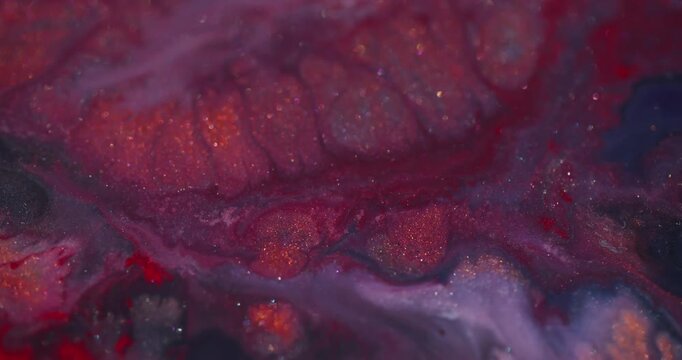 Glitter spill defocused. Ink blend. Red fluid explosion on shimmering color texture with purple gray particles on abstract background.