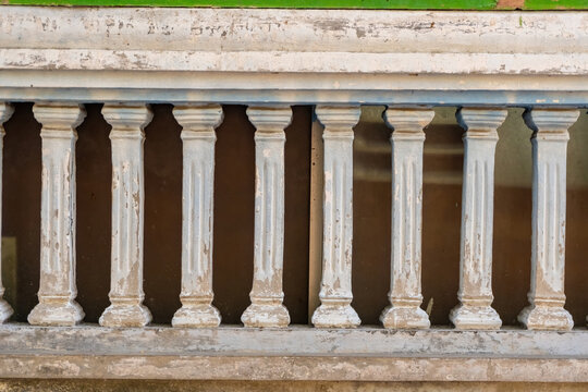 Old classic concrete balustrade fence or balcony railing on a vintage house building exterior. Minimal architectural detail texture backdrop template for grunge design.