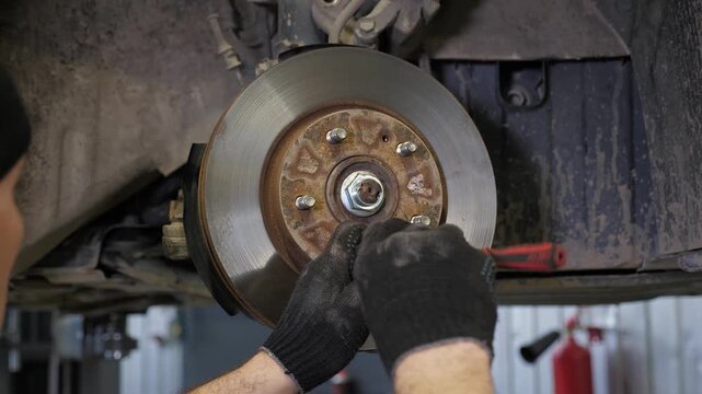 At the auto repair shop, the mechanic replaces the car's brake pads. When repairing the vehicle, the front brake pads are changed. This is a modern auto repair shop.
