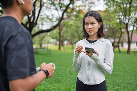 Gen Z Asian woman and African American mixed race man multicultural friends in urban park representing diversity wellness and positive active lifestyle.