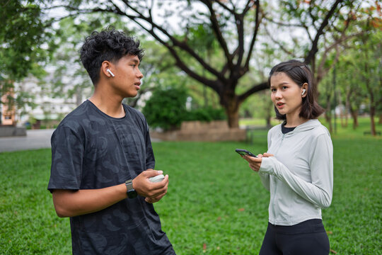 Gen Z Asian woman and African American mixed race man multicultural friends in urban park representing diversity wellness and positive active lifestyle.
