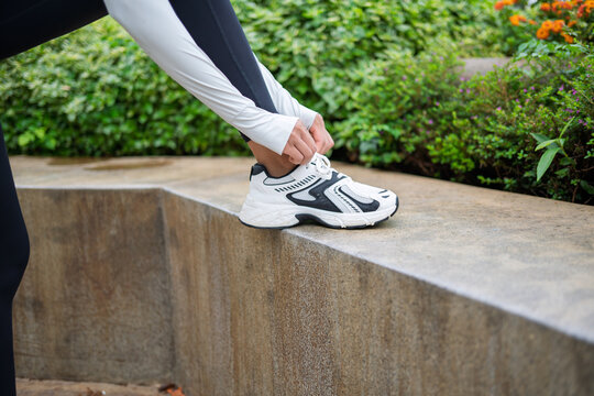 Asian woman preparing for running in green urban park for wellness and healthy city lifestyle