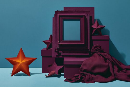 Empty magenta picture frame on layered paper with star cutouts and draped fabric for Juneteenth, deep plum and teal backdrop with copy space