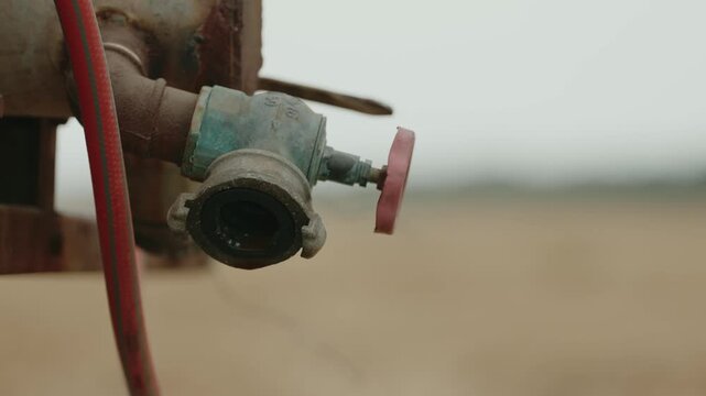 Water Dripping from Farm Tank Valve in Agricultural Field, 4K