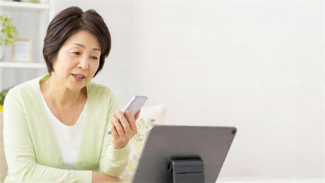 別のタブレットで公式窓口を確認するシニア女性