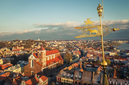 Kaunas, Lithuania - 19th november, 2024: aerial view beautiful metal artwork golden plate on top of town hall tower. Cathedral-Basilica of St. Peter and St. Paul and Kaunas cityscape 4k panorama