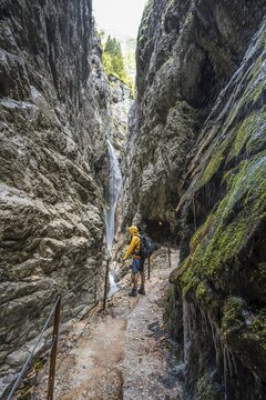 Mountaineers on their way through the H&ouml;llentalklamm, narrow rock gorge with mountain stream and waterfall, Wetterstein Mountains, Garmisch-Partenkirchen, Werdenfelser Land, Upper Bavaria, Bavaria, Germany