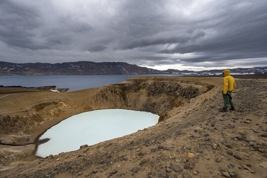 Tourist at the crater rim, crater lake V&iacute;ti and &Ouml;skjuvatn in the crater of Askja volcano, volcanic landscape, mountain massif Dyngjufj&ouml;ll, Icelandic highlands, Vatnaj&ouml;kull National Park, Iceland