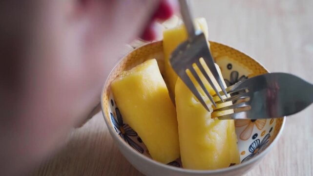 Close up top view video of opening fermented cassava or Tapai Singkong with a fork to show its soft texture inside a woven bamboo basket.