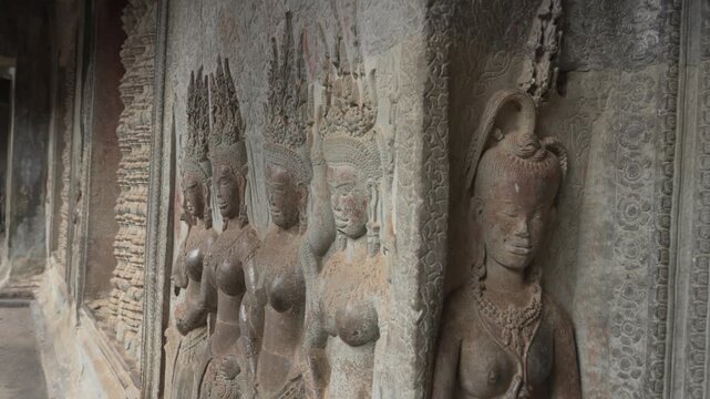 Row of Ancient Devata Stone Sculptures at Angkor Wat, Cambodia