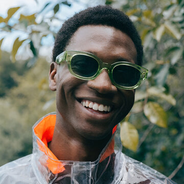 man wearing rain jacket and sunglasses smiling
