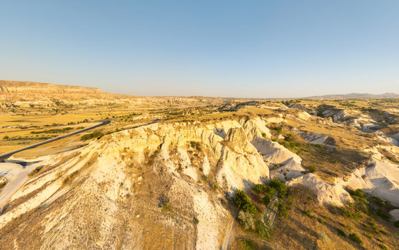 Goreme, Nevsehir, Turkey. Expansive aerial panorama over the Cappadocia plateau and eroded valley slopes near Love Valley, showcasing arid volcanic tuff terrain under soft afternoon light