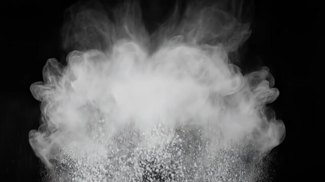 Explosion of white powder particles captured against a solid black background