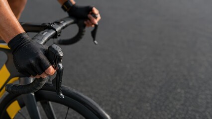 Fototapeta premium Close Up of Professional Road Cyclist Hands on Handlebars During High Speed Ride