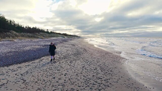 Woman Walking Toward Camera Along Nida Pebble Beach on Latvia Baltic Sea Coast
