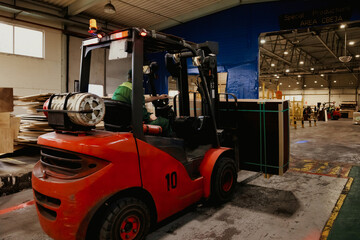 Red Forklift Transporting a Large Plywood Package Indoors at Warehouse © Aleksandr