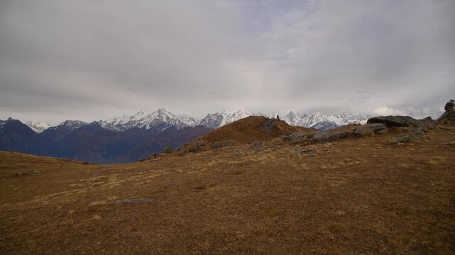 Moody Overcast Sky Over Vast Alpine Meadow And Snow Capped Himalayas Hiker Facing Massive Himalayan Peaks At Khaliya Top