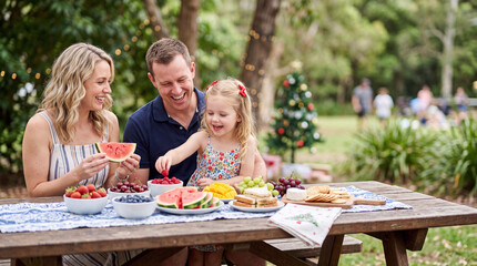 Obraz premium Family christmas picnic outdoors with parents and child sharing fruit and snacks for seasonal picnic banner and lifestyle background