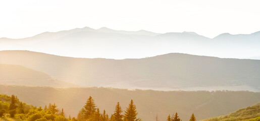 Obraz premium Golden sunrise over hazy mountain layers