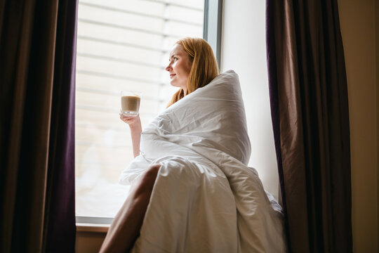 Woman enjoying a peaceful hotel morning with coffee
